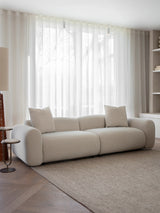 Warm stone velvet sofa in bright living room with sheer curtains