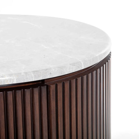Dark wood chest with a round white marble top, ribbed texture detail.