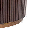 Dark wood chest corner with vertical grooves and rounded base.