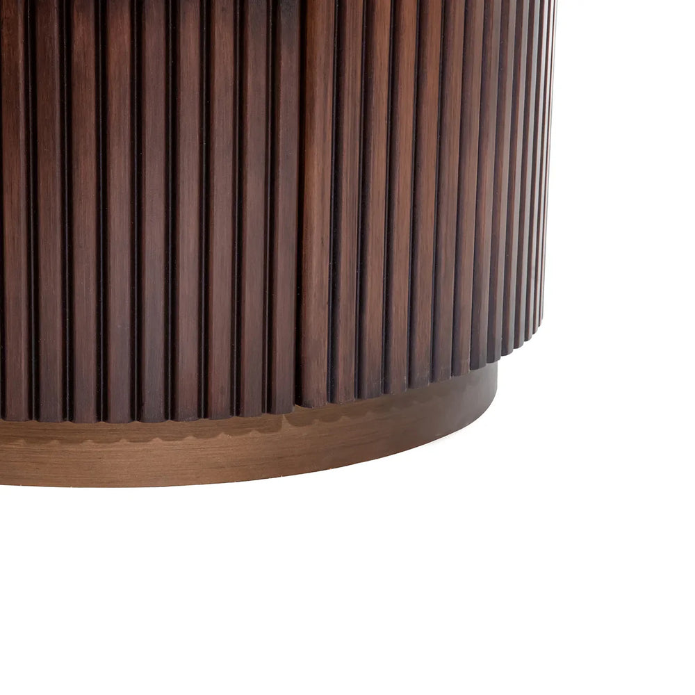 Dark wood chest with vertical grooved texture and rounded base.
