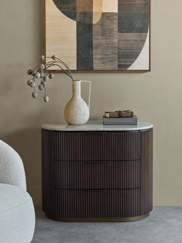 Dark wood chest with ribbed texture, styled in a modern room with art and decor.