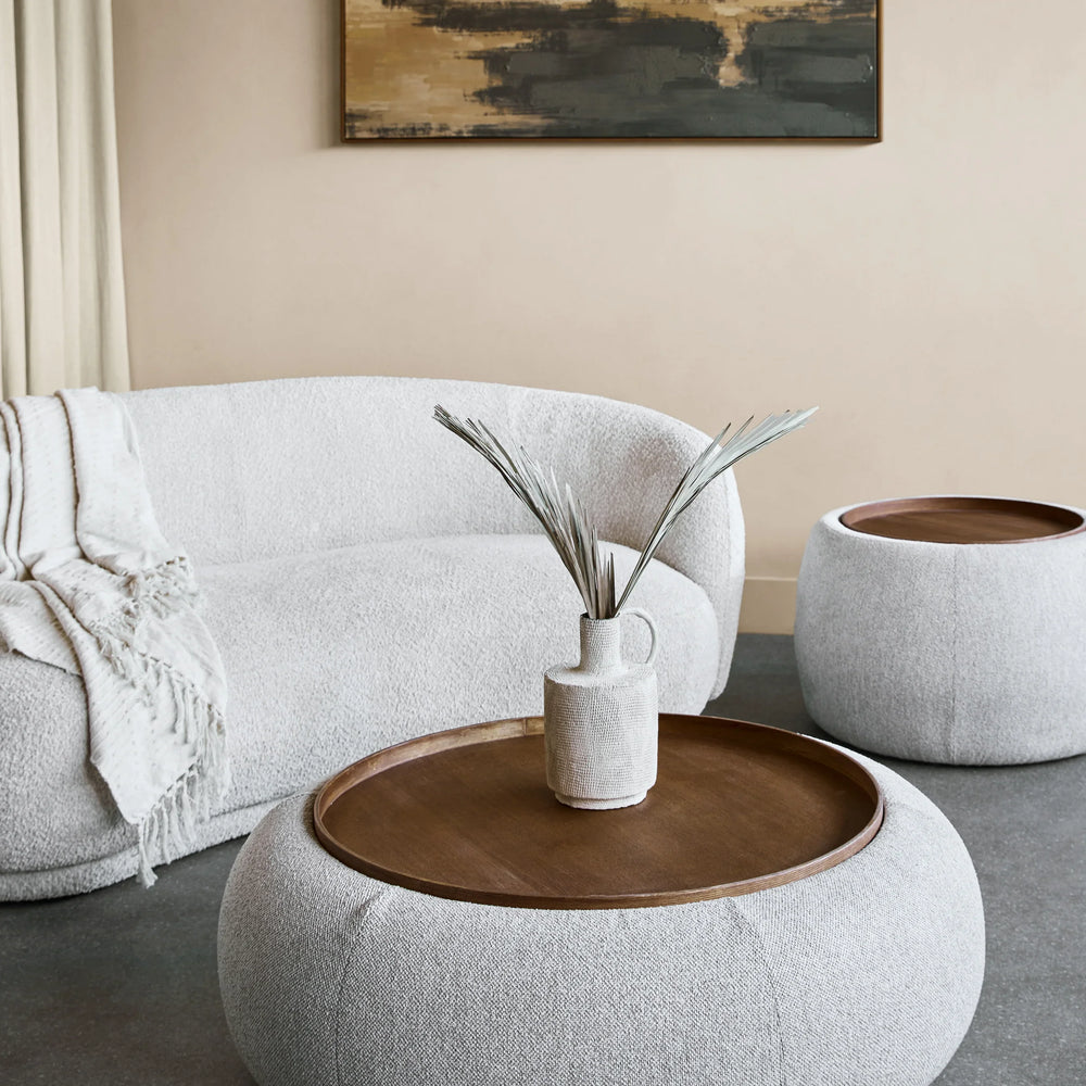 Oatmeal ottoman with wooden tray in modern living room setting.