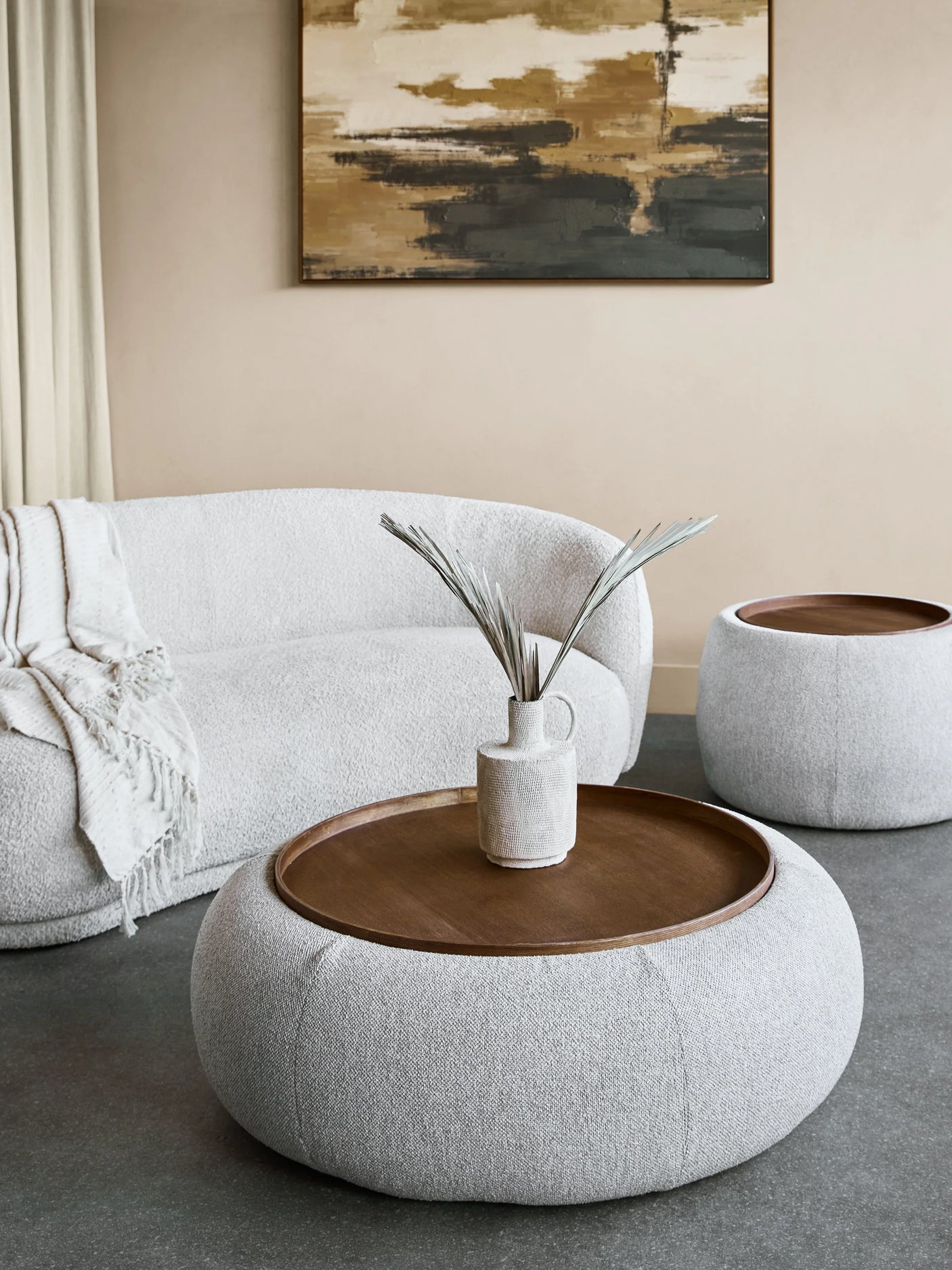 Oatmeal ottoman with wooden tray in modern living room setting.