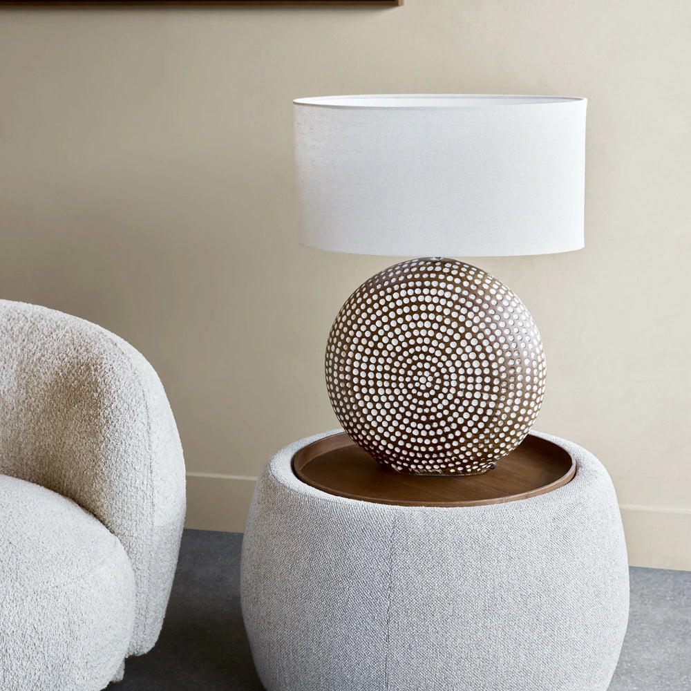 Oatmeal ottoman with decorative lamp in a modern living room setting.
