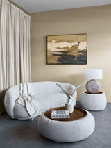 Oatmeal ottoman in a cozy living room with a sofa and abstract art.