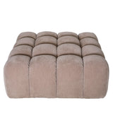 Beige tufted pouf with a soft, plush texture.