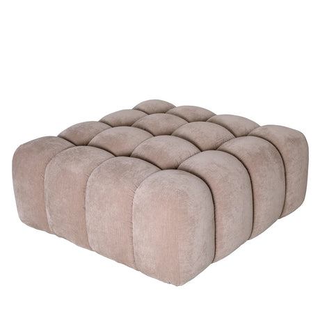 Beige upholstered pouf with tufted design and rounded edges.