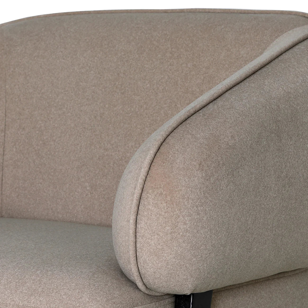 Beige chair armrest with soft, textured fabric detail.