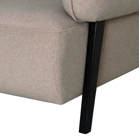 Beige fabric chair corner with black wooden leg detail.