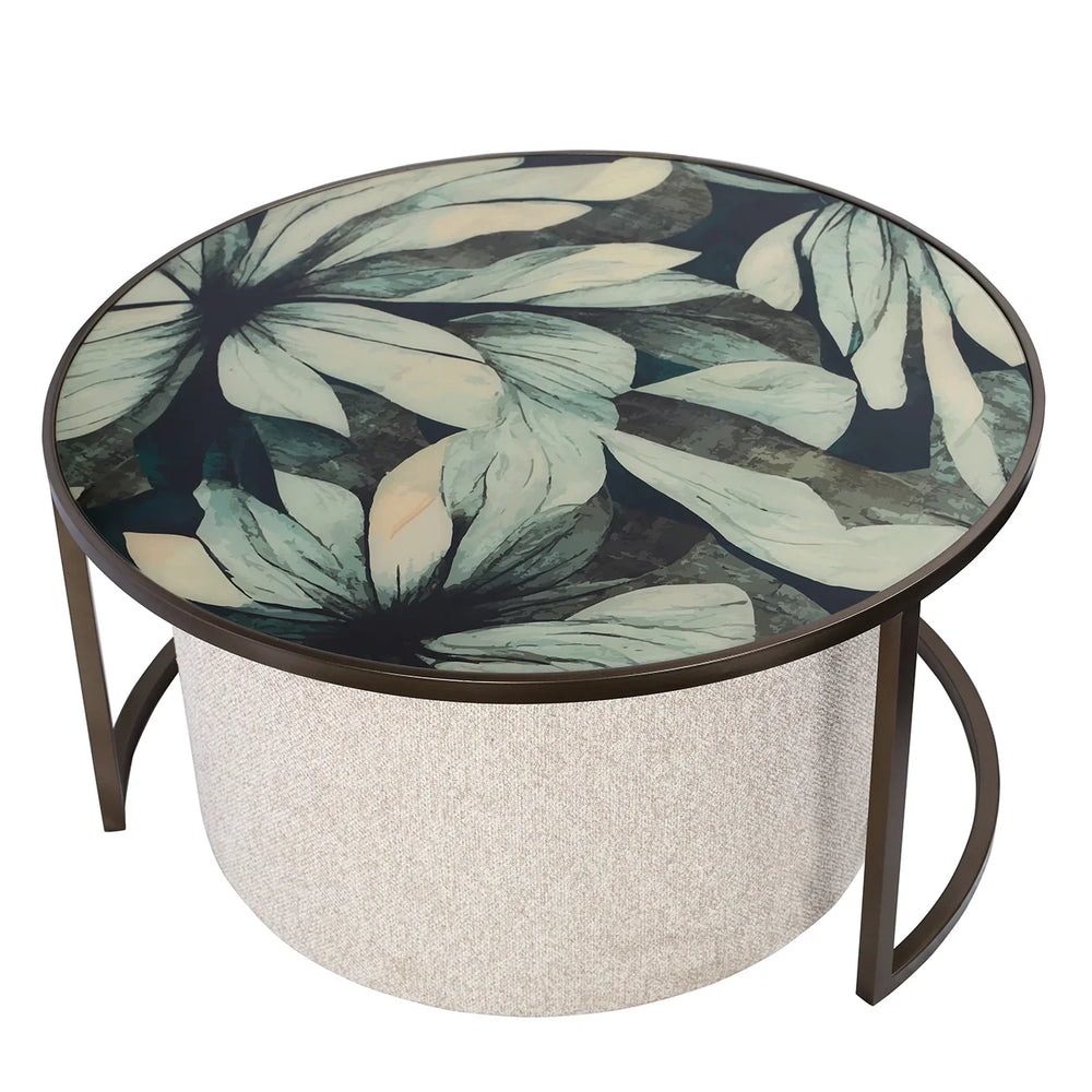 Round coffee table with floral glass top and textured pouffe base.