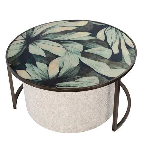 Round coffee table with floral glass top and textured pouffe base.