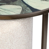 Beige textured pouffe with leaf-patterned table surface above.