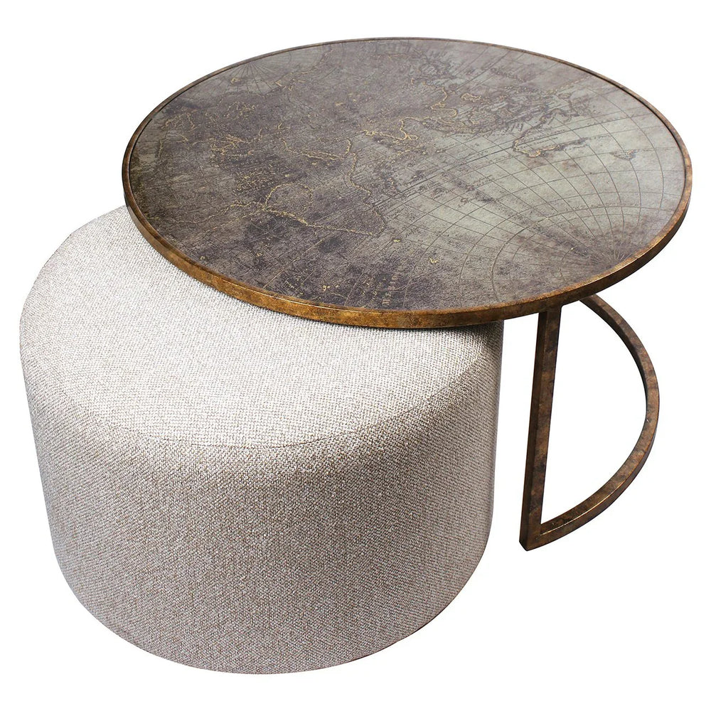 Round metal coffee table with world map design on beige pouffe.