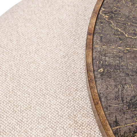 Beige textured pouffe beside a wooden map-themed table edge.
