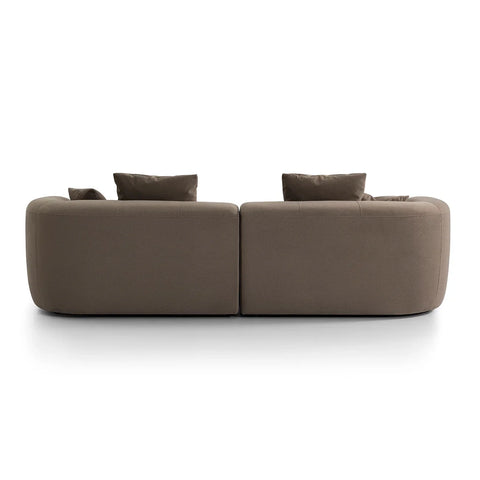 Back view of a brown velvet sofa with plush cushions.
