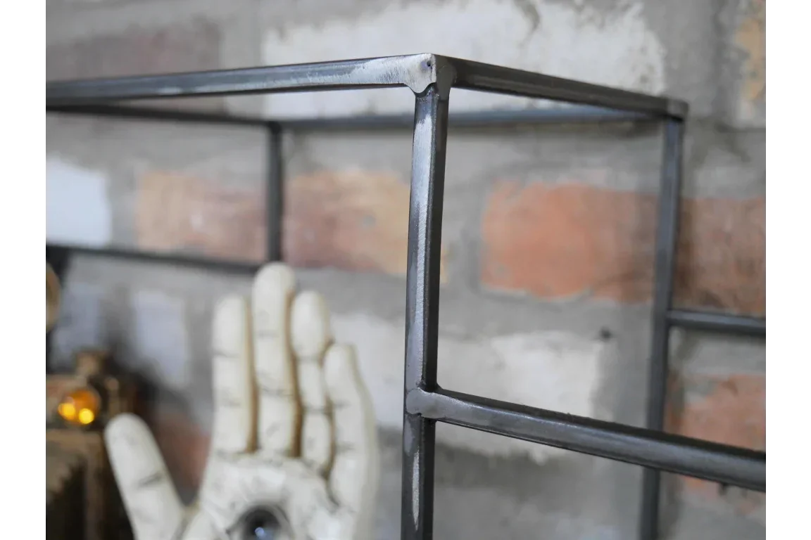 Industrial metal shelving frame with welded joints against brick wall