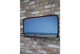 Wall-mounted rectangular mirror with black metal frame and wooden shelf in front, shown at slight angle.