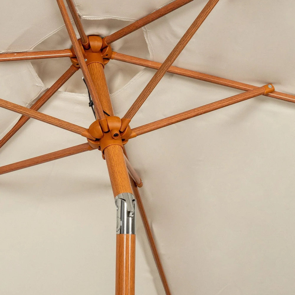 Close-up of wooden parasol frame with beige outdoor fabric canopy