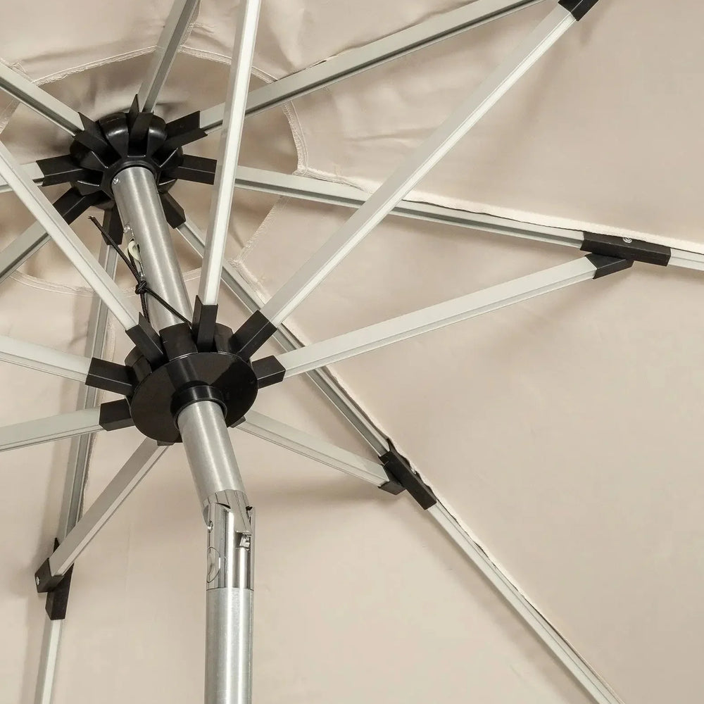 Close up of outdoor parasol frame with silver metal ribs and beige canopy fabric