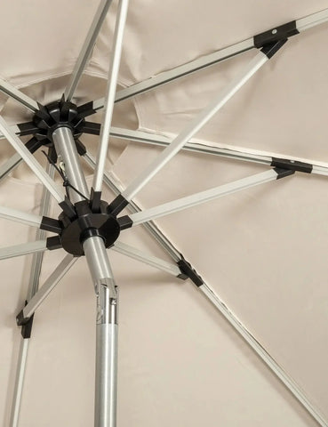 Close up of outdoor parasol frame with silver metal ribs and beige canopy fabric