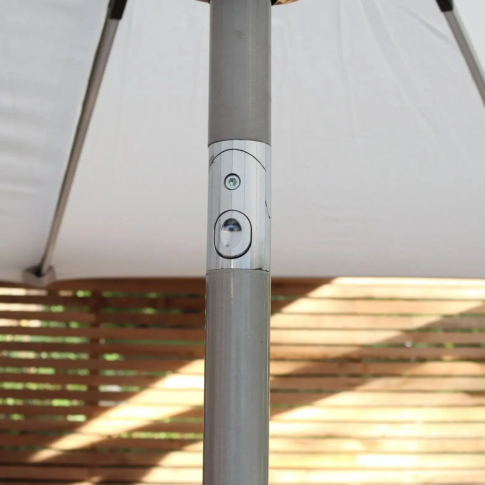 Close up of outdoor parasol pole with tilt mechanism beneath white canopy