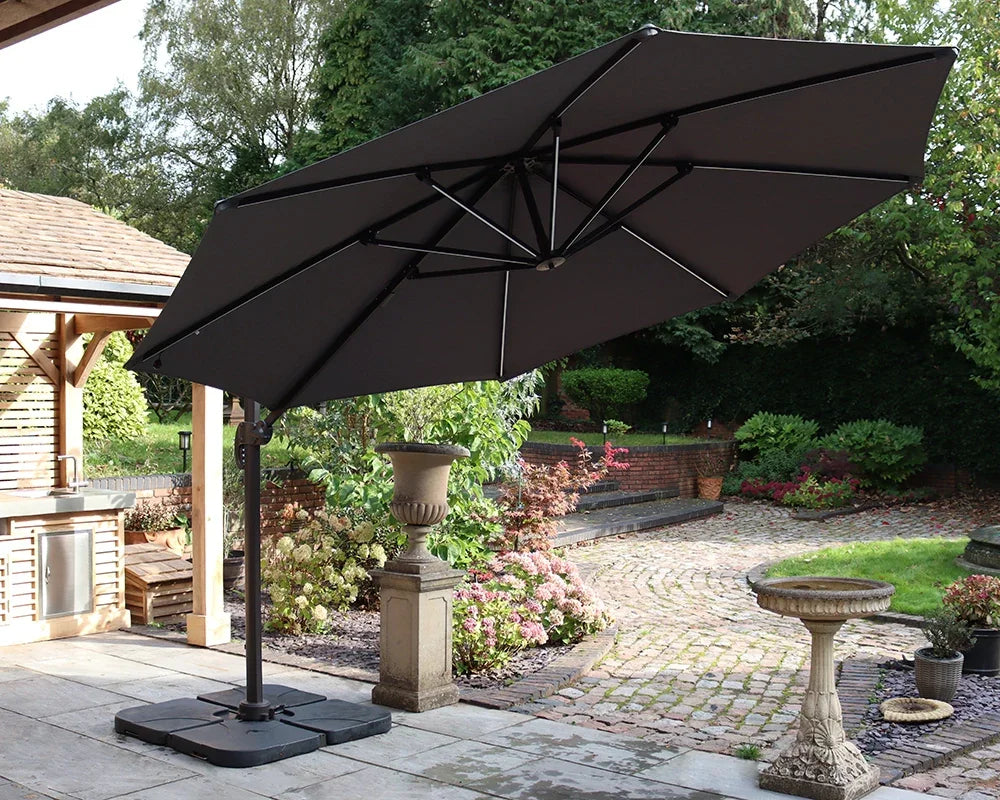 Black cantilever garden parasol on patio with weighted base in landscaped backyard