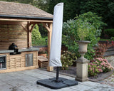 Garden parasol with protective cover beside outdoor kitchen and patio planters