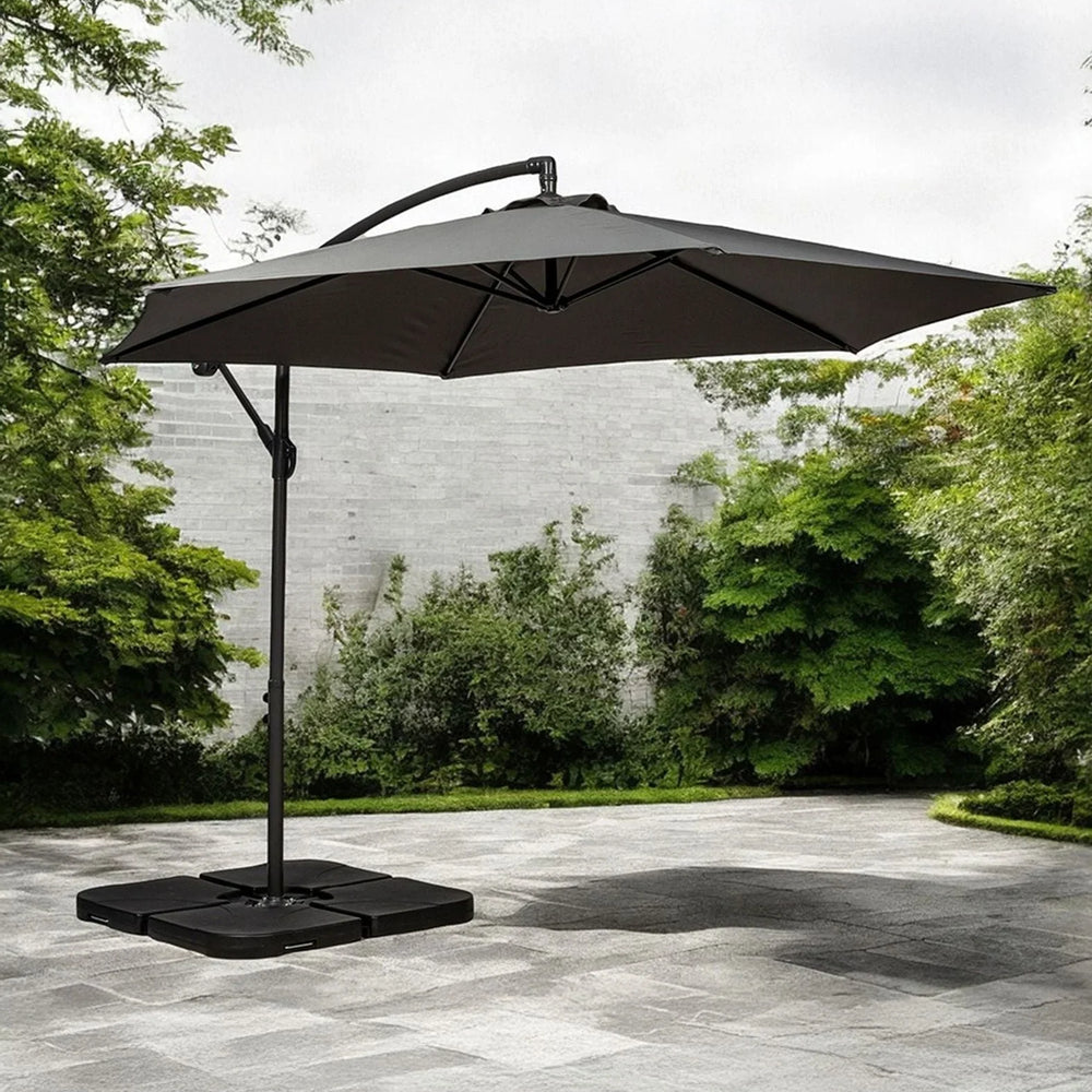 Cantilever garden parasol with dark canopy and sturdy base on stone patio