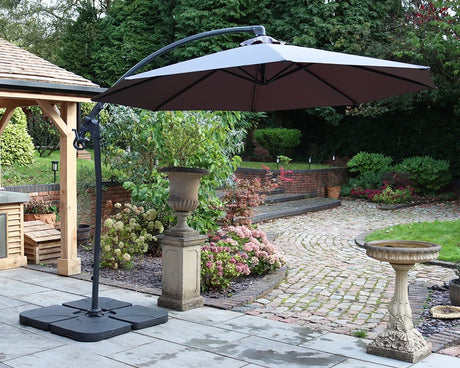 Cantilever garden parasol with black base on stone patio in landscaped backyard