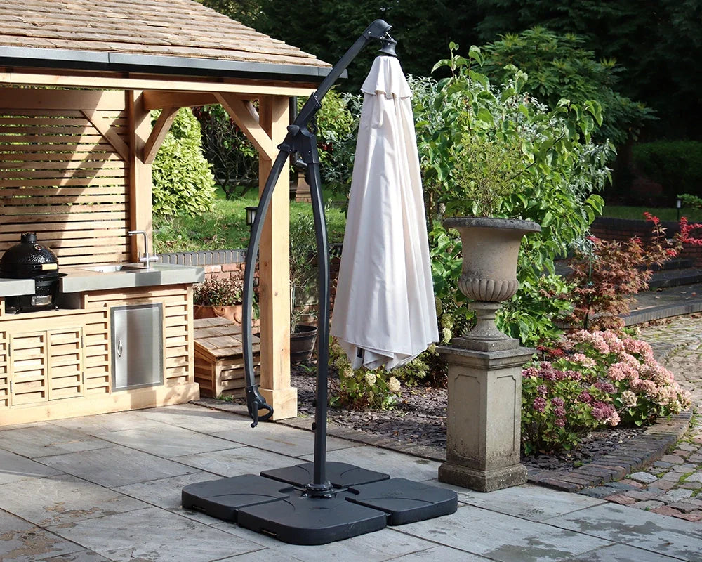 Beige outdoor cantilever parasol with black base on patio beside wooden garden gazebo