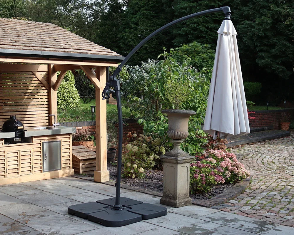 Cantilever patio parasol with closed cream canopy on tiled garden terrace