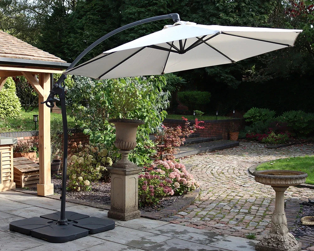 Cream garden cantilever parasol with black frame on patio in landscaped backyard