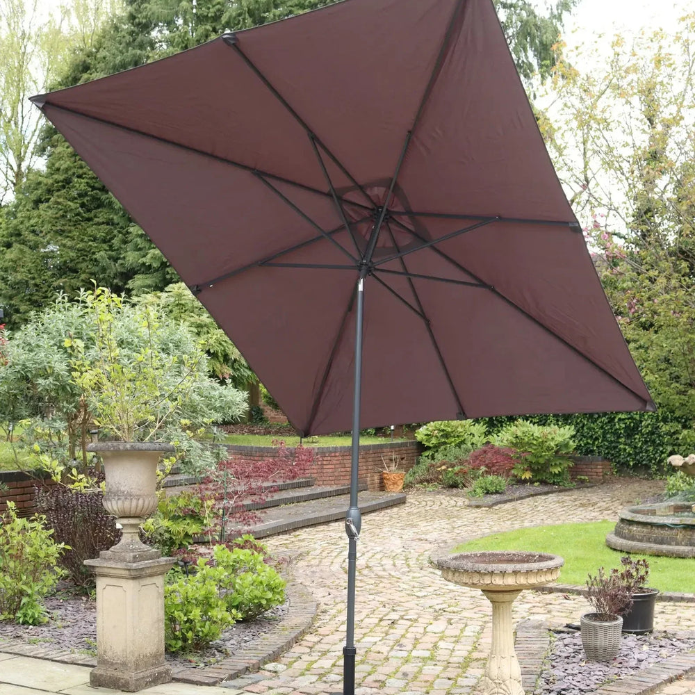 Brown cantilever garden parasol with black base on stone patio in landscaped backyard