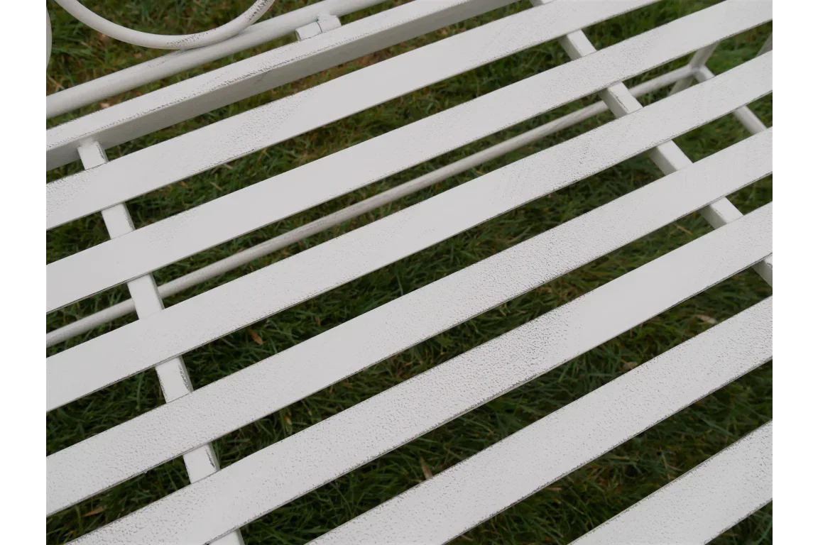White metal garden bench slatted seat closeup on grass