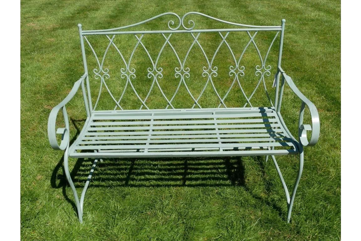 green metal garden bench with decorative scroll design on lawn