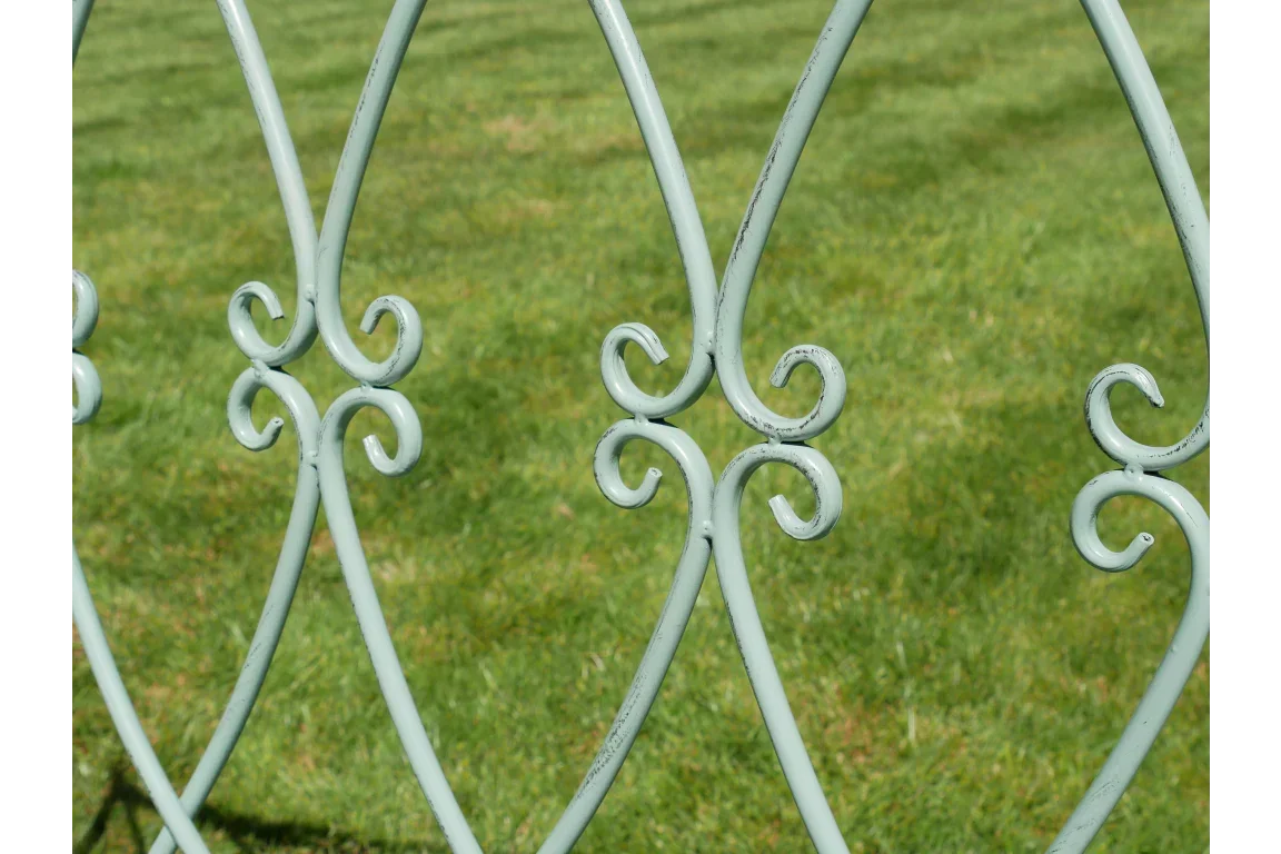 Decorative metal garden furniture detail with green lawn background