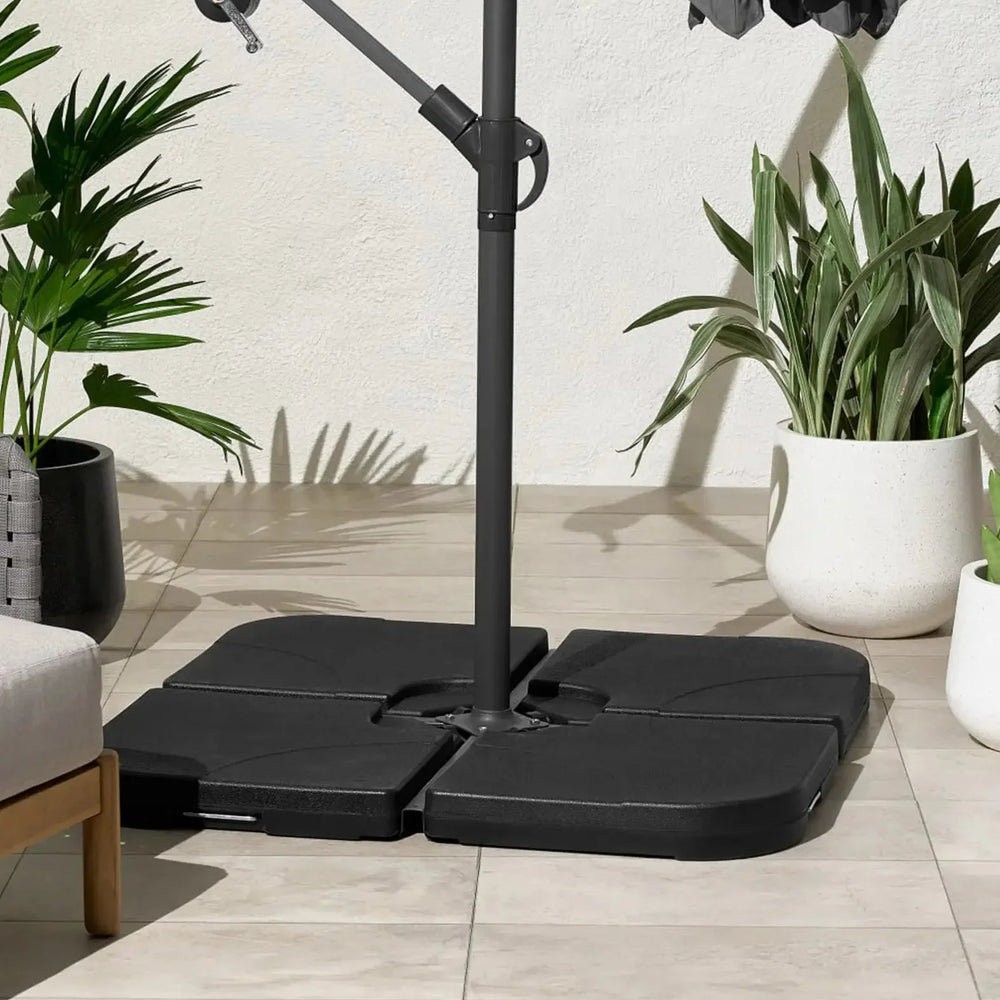 Garden parasol base set on tiled patio beside potted plants and outdoor furniture