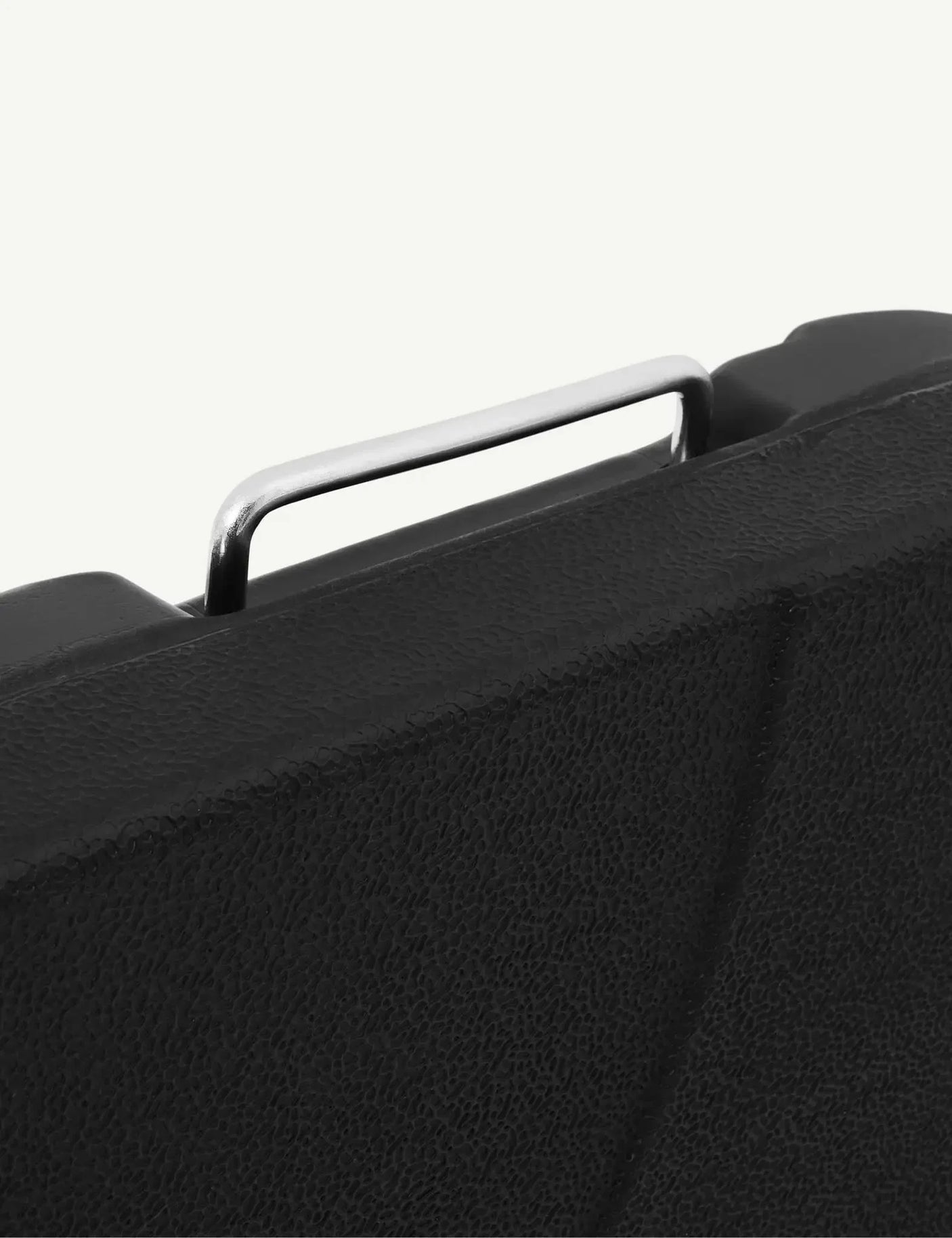 Textured black case with silver metal handle close up, durable storage solution detail