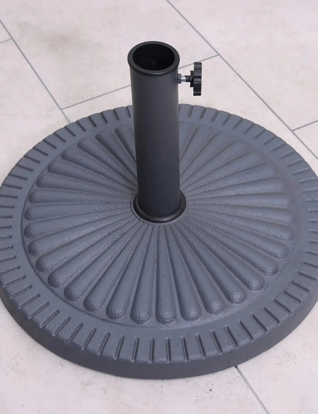 Round cast iron parasol base with ribbed pattern on tiled patio floor
