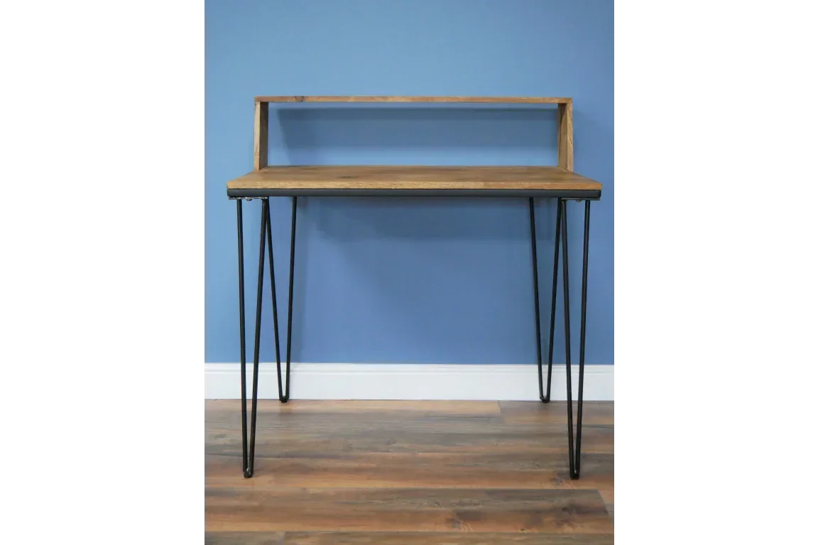 Industrial wood desk with shelf and black hairpin legs against blue wall