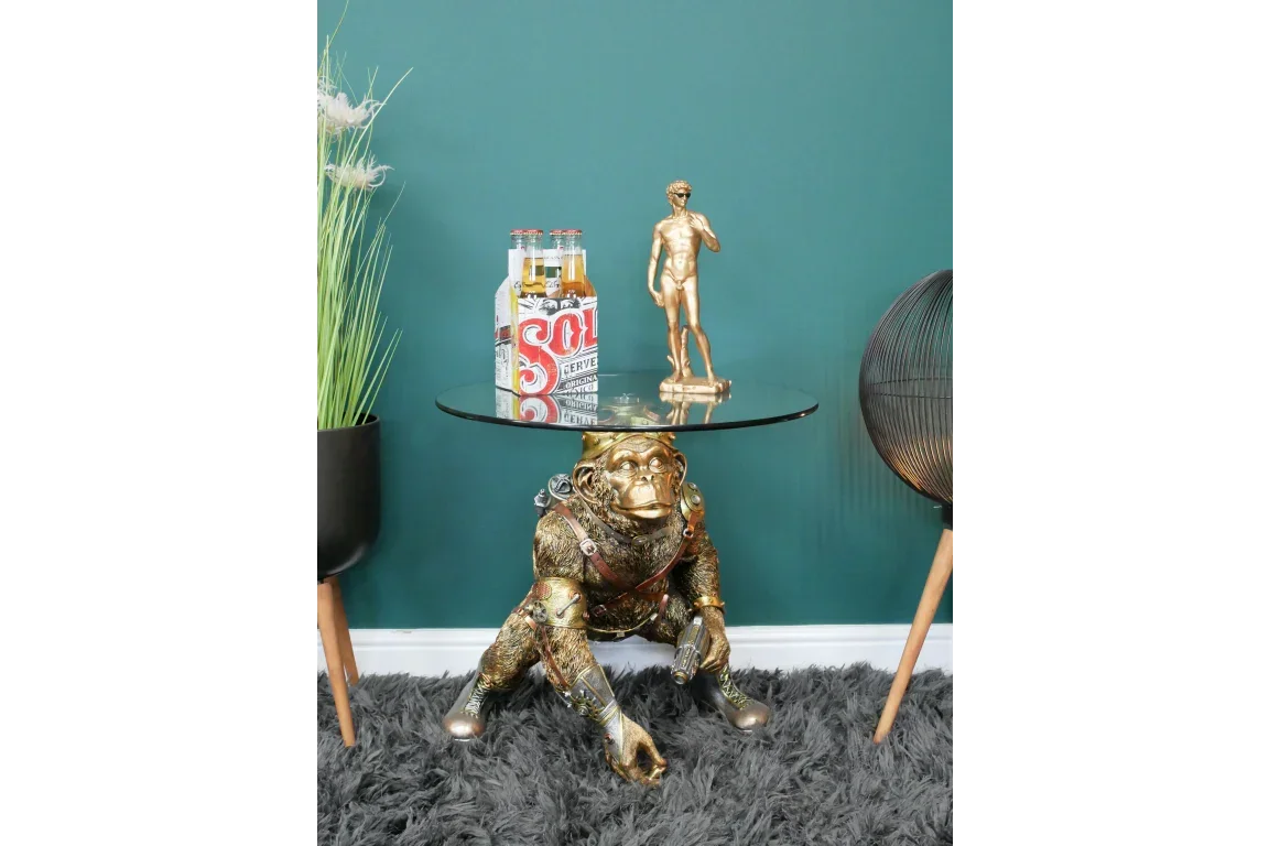 Gold monkey side table with glass top in living room, drinks and statue displayed on surface