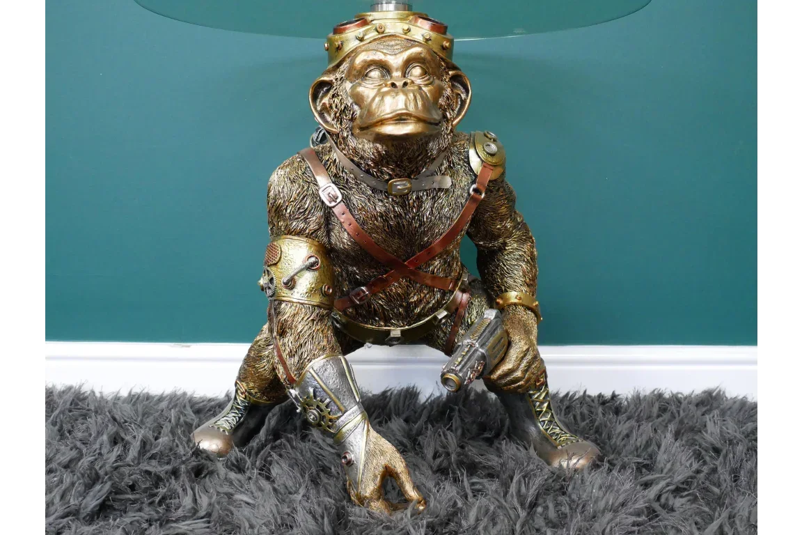 Steampunk monkey table lamp with metallic finish and glass top on shaggy rug