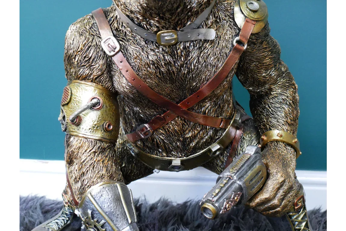 Steampunk animal figurine with brown fur, metallic armor, leather straps and futuristic weapon