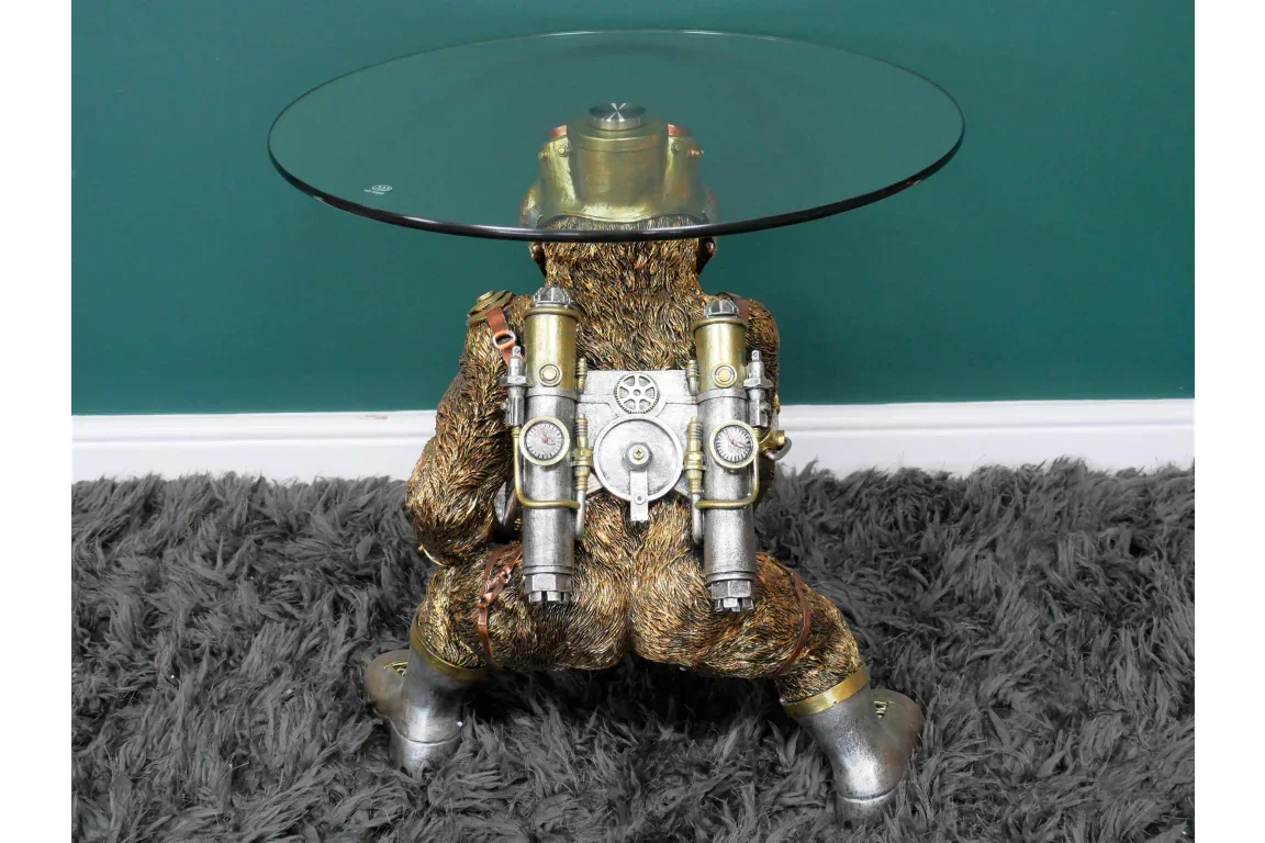 Steampunk monkey side table with glass top and metallic backpack base on grey rug