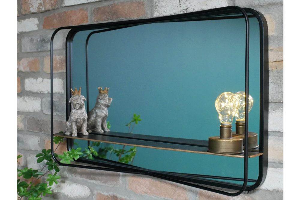 Rectangular black metal framed wall mirror with shelf holding two dog figurines and a decorative light bulb.