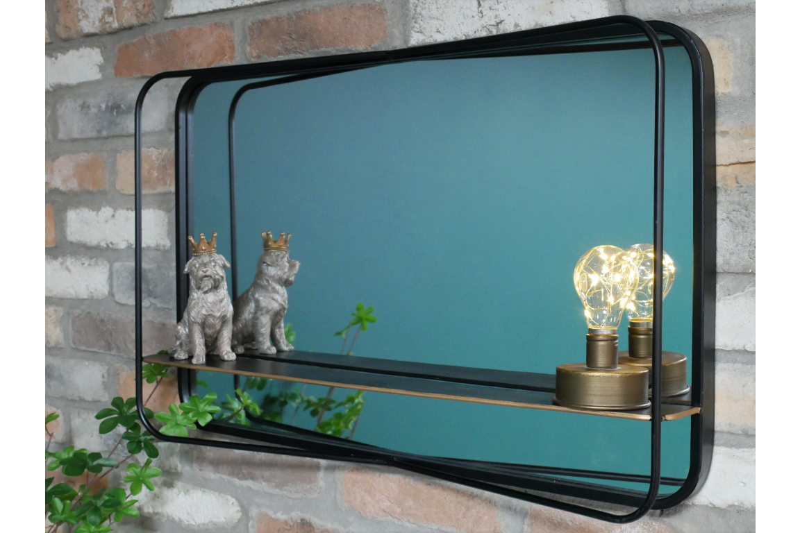 Rectangular black metal framed wall mirror with shelf holding two dog figurines and a decorative light bulb.
