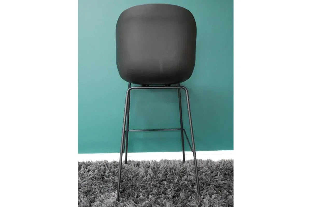 Black bar stool with curved backrest and metal legs on grey rug