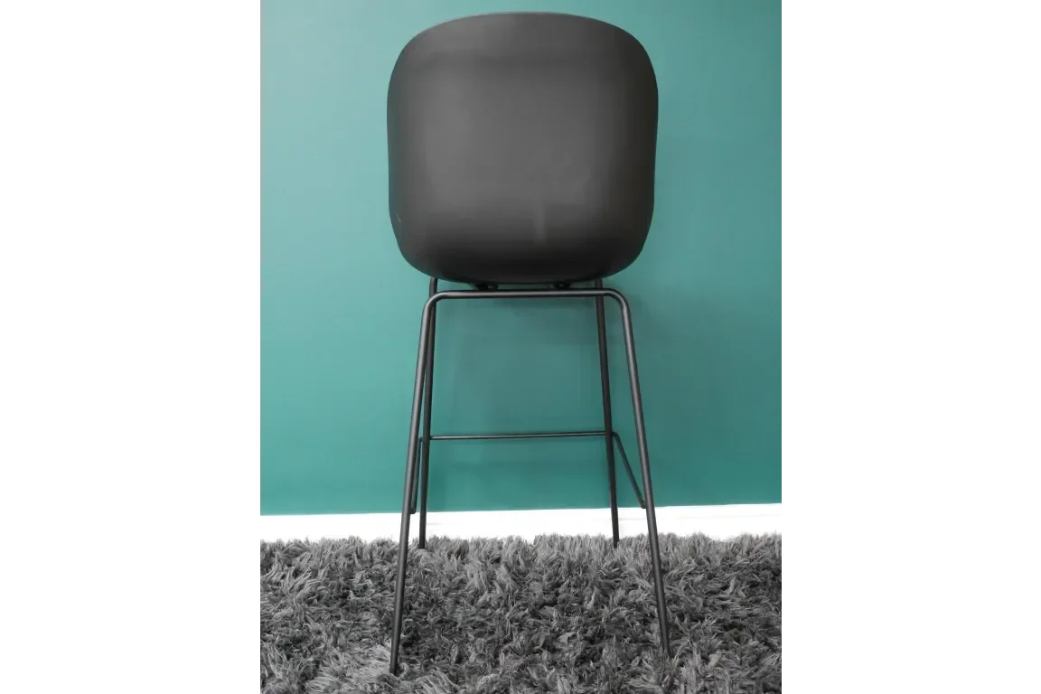 Black bar stool with curved seat and metal legs on grey rug