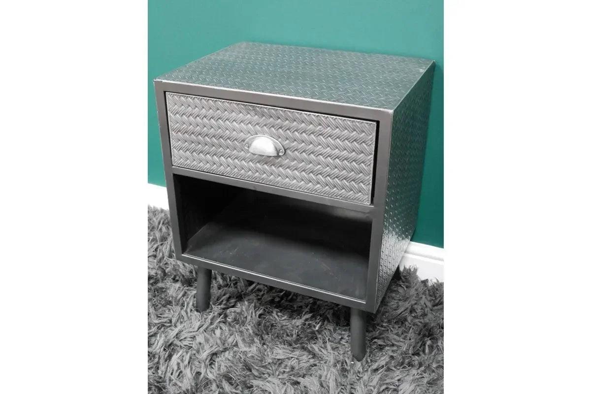 Metal bedside table with single drawer, open shelf, and diamond plate pattern on carpet