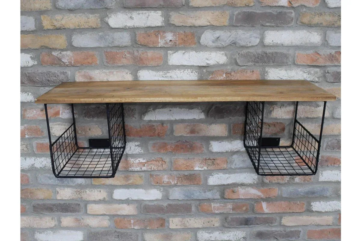 Wall mounted shelf with wood top and black metal wire storage baskets against brick wall